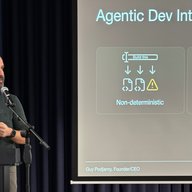 Man standing at podium presenting slide on Agentic Development